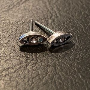 Silver eye shaped stud earrings with a crystal.